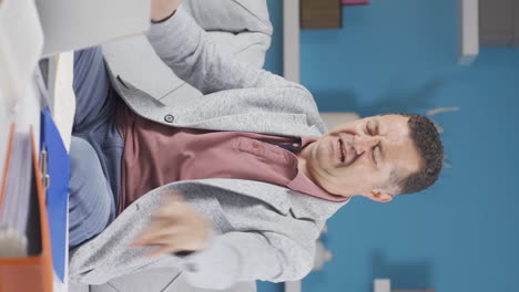 Vertical-video-of-Home-office-worker-old-man-looking-at-the-file-angrily.